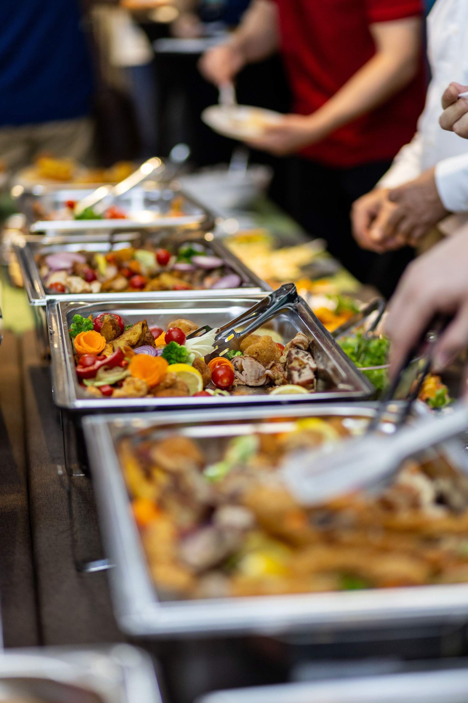 Buffet featuring a variety of fresh salads and main dishes at a lively gathering event
