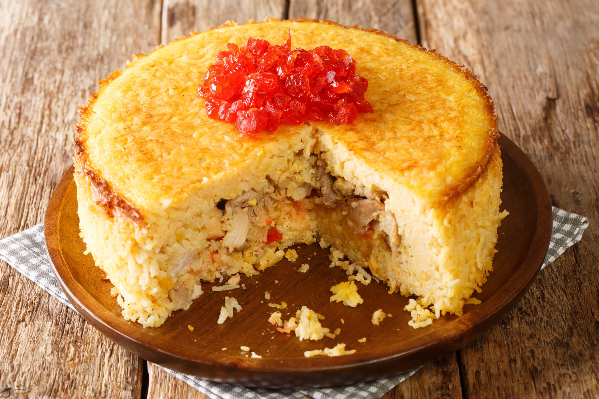 Tahchin or tah-chin, is an Iranian rice cake primarily consisting of rice, yogurt, saffron, and eggs stuffed with chicken fillets closeup in the plate. horizontal